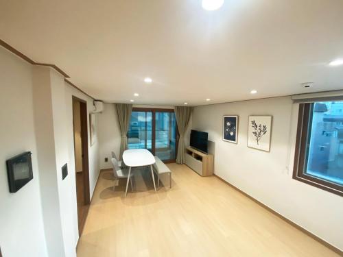 ein Wohnzimmer mit einem weißen Tisch und einem Fenster in der Unterkunft Luxe & Suite Room in Seoul