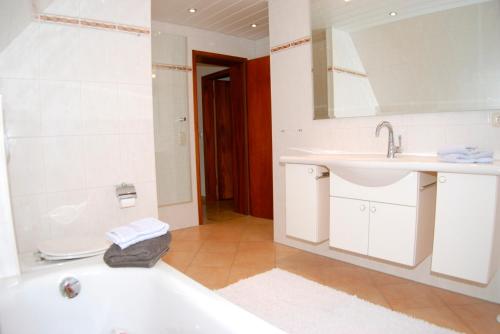 uma casa de banho com uma banheira, um lavatório e um espelho. em FW Hannelore em Grossenbrode