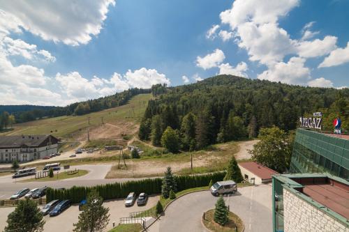a view of a parking lot with a mountain at Hotel Pegaz in Krynica Zdrój