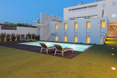 two chairs and a swimming pool in front of a building at Uporto House Residence in Porto
