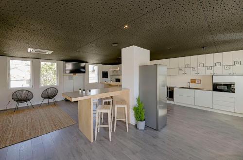 a large kitchen with a counter and stools in it at Uporto House Residence in Porto