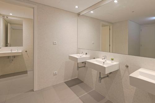 a bathroom with two sinks and two mirrors at Uporto House Residence in Porto