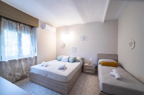 a bedroom with two beds and a window at WiBnB Holiday rentals- appartamenti in Turin