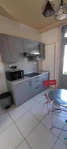 une cuisine avec une cuisinière et une table à l'intérieur dans l'établissement Gite La Revinoise, à Revin