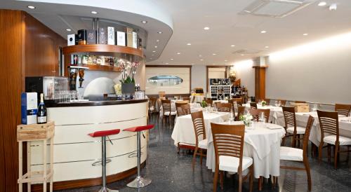 ヴィアレッジョにあるHotel Mirageのテーブルと椅子のあるレストラン、バー