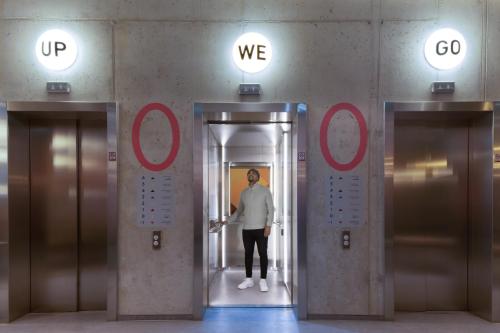 a man standing in the middle of an elevator at Basecamp Hotel Dortmund in Dortmund