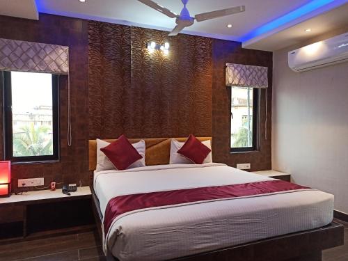 a bedroom with a large bed and two windows at Hotel A P Home's - A Boutique Hotel in Guwahati