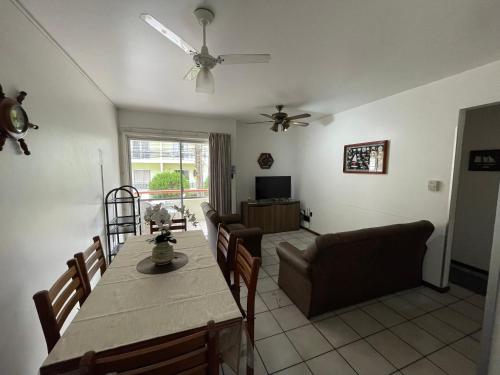 a living room with a table and a couch at Lindo apartamento super completo em Meia Praia, 100 metros do mar e 10 quadras do centro in Itapema