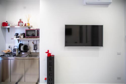 una cucina con lavandino e una TV a parete di Vhouse Fiumicino a Fiumicino