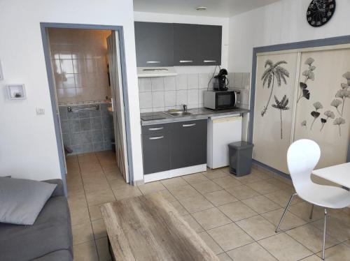 a small kitchen with a sink and a microwave at Studio 2 personnes en centre ville in Saint-Pierre-de-Plesguen