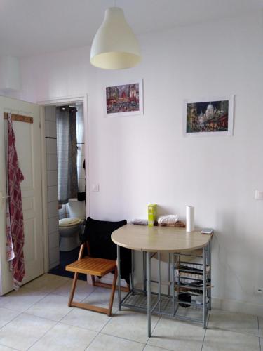 une salle à manger avec une table et une salle de bains. dans l'établissement logement indépendant à 20 mn du coeur de Paris, à Clichy