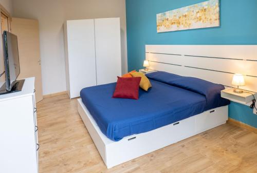 Un dormitorio con una cama grande con una pared azul. en Deluxe Sicily Villa, en Buonfornello