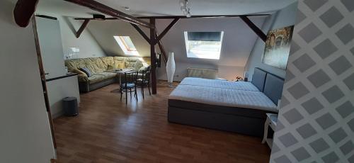 sypialnia z łóżkiem i kanapą w pokoju w obiekcie Apartment Lutherrose w mieście Eisleben