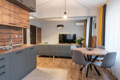 een keuken met een tafel en stoelen en een woonkamer bij Апартаменти 22 in Velingrad