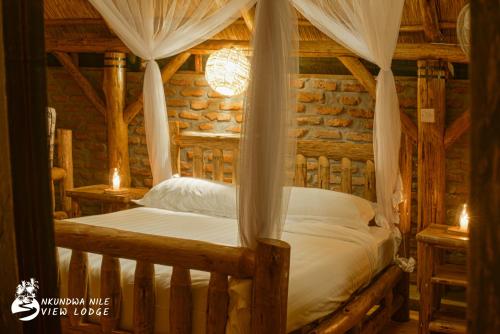 a bedroom with a bed in a log cabin at NKUNDWA NILE VIEW LODGE in Wanseko