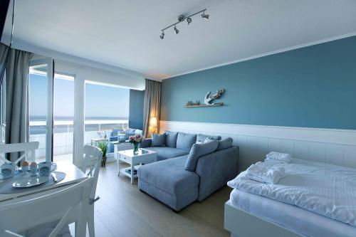 a blue living room with a couch and a table at Lotsenbude in Büsum