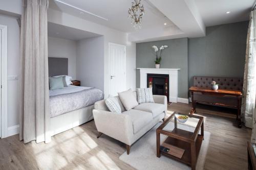 a bedroom with a bed and a couch and a chair at Beech House - Urban Apartments in Bristol
