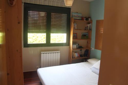 a bedroom with a white bed and a window at Dolcesa in Vall-Llobrega