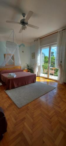 Villa Mira Bed and Breakfast في دوينو: غرفة نوم بسرير ونافذة كبيرة