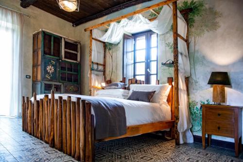 波佐利的住宿－Masseria del Carmine Maggiore 1817，一间卧室设有木制天蓬床和窗户。