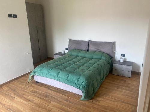een groen bed in een kamer met een houten vloer bij CASA CAMILLA in Portovenere