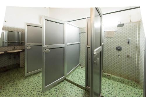a bathroom with two stalls with a shower at Zizina Otis Resort in Guwahati