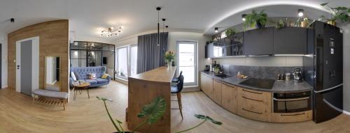 une cuisine et un salon avec un îlot dans une maison dans l'établissement Loft Apartament Patio Vita- Klimatyzacja Garaż podziemny, à Kielce