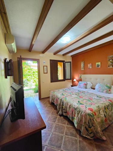 a bedroom with two beds and a flat screen tv at Hotel Doñana Blues in Matalascañas