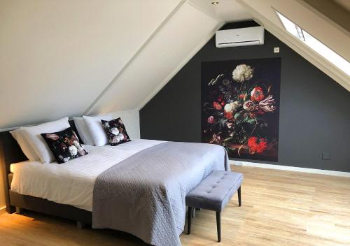 a bedroom with a bed with a painting on the wall at Erf Hesse - holiday home in Ommen