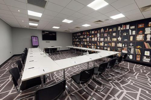 a conference room with a long table and chairs at Village Hotel Maidstone in Maidstone