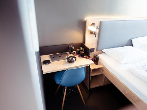 a bedroom with a bed, desk, and a computer at aletto Hotel Kudamm in Berlin