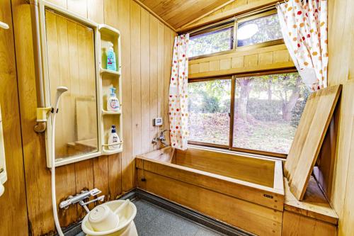 a bathroom with a tub and a toilet and a window at Stay and Discover Nishinoya in Senboku