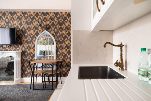 a kitchen with a black sink and a table at City Centre All In One Apartment by BookingHost in Warsaw