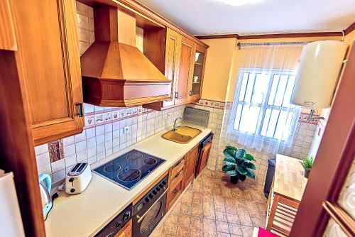 a kitchen with a sink and a stove top oven at Plaza de Cárcel 3-bedroom Apartment in El Puerto de Santa María
