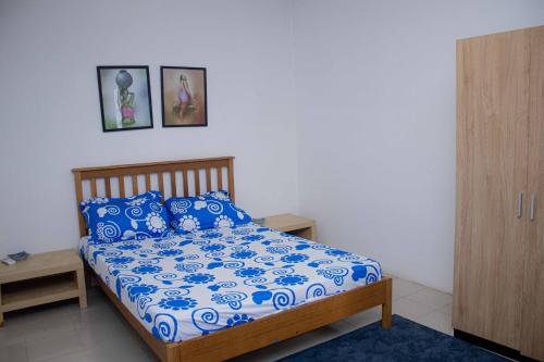 a bedroom with a bed with blue and white sheets at Super villa avec garage véhicule à 2 mn de la mer in Lomé