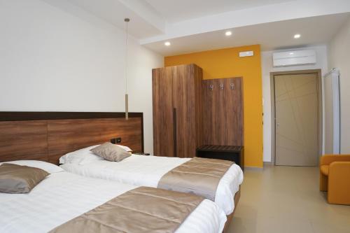 ein Hotelzimmer mit 2 Betten und einer gelben Wand in der Unterkunft Villa Mafalda B&B in Frattamaggiore
