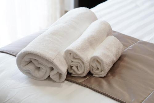 2 asciugamani posti sopra un letto di Villa Mafalda B&B a Frattamaggiore