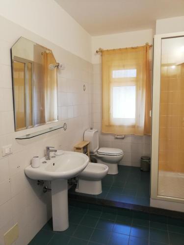a bathroom with a sink and a toilet and a mirror at Etna Casa del Sole in Nicolosi