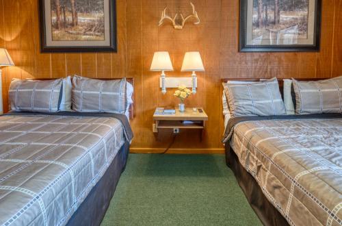 a hotel room with two beds and a side table at Sabinal Inn in Sabinal