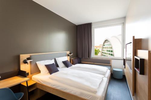 a bedroom with a large bed with a window at aletto Hotel Kudamm in Berlin