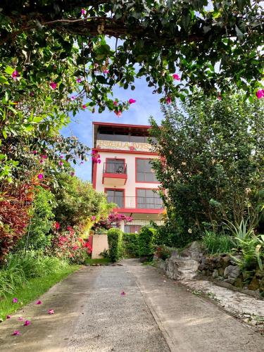 a pink building with flowers in front of it at Buena Vista Boquete in Boquete