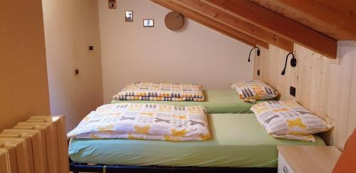 2 aparte bedden in een kamer met bij Chalet Rasia in Livigno