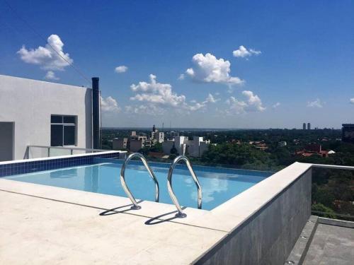 a swimming pool on the roof of a building at Departamento loft con estacionamiento in Asuncion