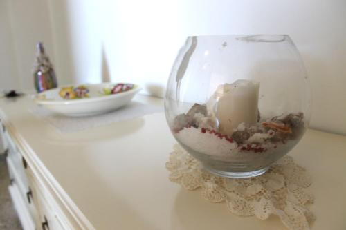 a glass vase with a candle in it on a counter at Vent In Costa Ospitalità Diffusa in Furore