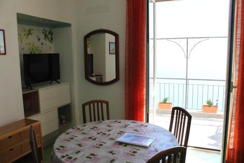 a dining room with a table and a television at Vent In Costa Ospitalità Diffusa in Furore
