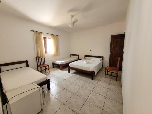 a room with two beds and two chairs in it at Hotel Guarini in Monte Sião