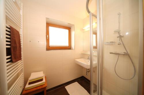 a white bathroom with a shower and a sink at Appartement Kristall in Schladming