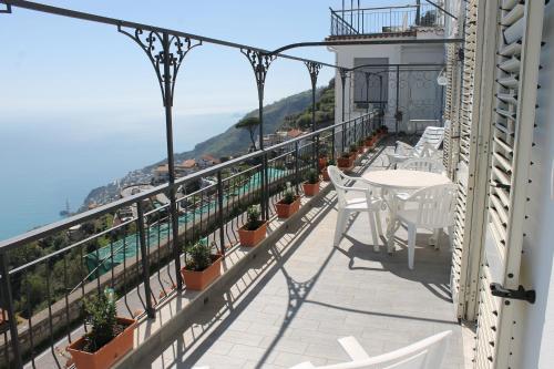 a balcony with white chairs and a view of the ocean at Vent In Costa Ospitalità Diffusa in Furore