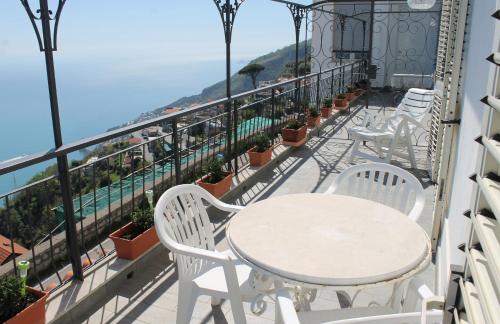 a balcony with tables and chairs and a view of the ocean at Vent In Costa Ospitalità Diffusa in Furore