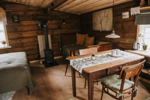 um quarto com uma mesa e uma cama num camarote em Vienkiemio Oazė - Namelis Prie Šermukšnio em Galvokai